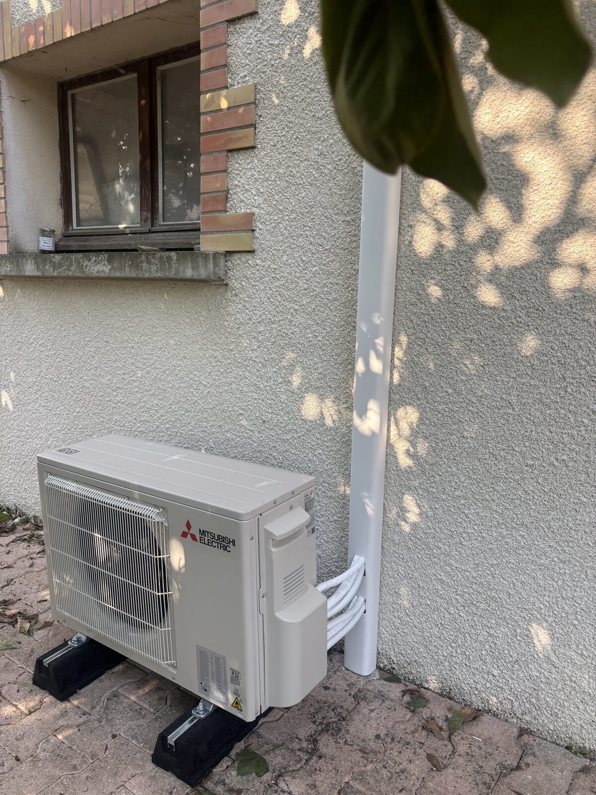 Unité extérieure Mitsubishi Electric installée côté jardin